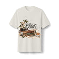 Bone heavyweight T-shirt, front view, with The Ordinary Archive still-life graphic featuring a camera, books, blossoms and a mug.